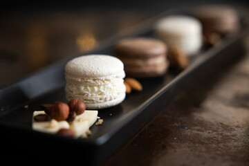 white and chocolate macaroni cookies on a black plate