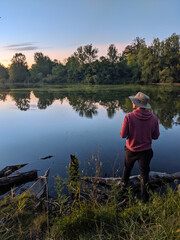 Fototapeta na wymiar Fisherman on a small pond fishing sunset 