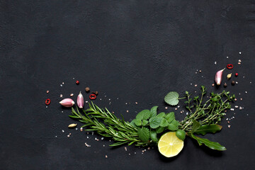 Herbs and spices lime slice, Melissa, rosemary, thyme, Bay leaf, garlic on a black background.