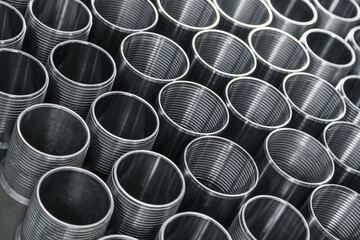 Pattern of metal cylinders stand on table at factory. Steel products to automotive industry. Billet...