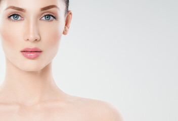 Obraz premium Beautiful face of young adult woman with clean fresh skin. Looking at Camera.