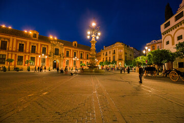 Fototapeta na wymiar Night view of the Plaza Virgen de los Reyes with the Giralda and the cathedral of Seville, Spain.