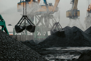 port cranes are loading coal into a transporting train. - obrazy, fototapety, plakaty