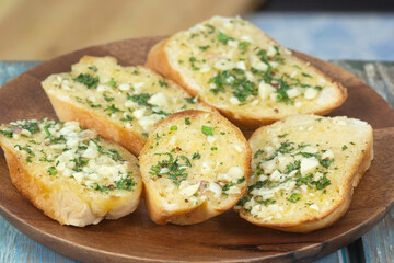 Garlic bread on the wooden plate