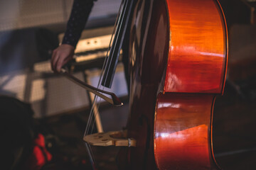 Concert view of a contrabass violoncello player with vocalist and musical during jazz orchestra...