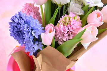 Beautiful elegant spring bouquet for greeting on pink background, selective focus, copy space. Bunch of tender tulips, eustoma flowers and hyacinthus. Romantic bouquet of flowers. Mother’s Day