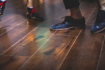 Dancing shoes of young couple dance retro jazz swing dances on a ballroom club wooden floor, close up view of shoes, female and male, dance lessons