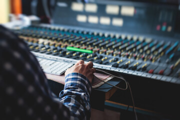 Sound editor engineer working at studio with mixing panel, mixing music and sound, stage sound...