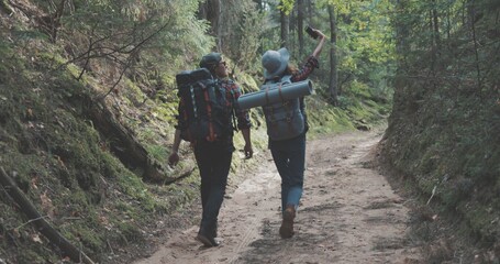 young man and woman hiking in forest