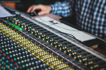 Sound editor engineer working at studio with mixing panel, mixing music and sound, stage sound...