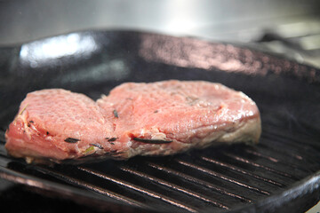 Grilling steak on a grill pan. Chef making steak. Beef tender steak on the grill pan. 