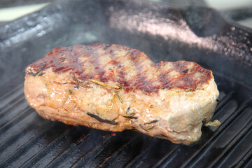 Grilling steak on a grill pan. Chef making steak. Beef tender steak on the grill pan. 