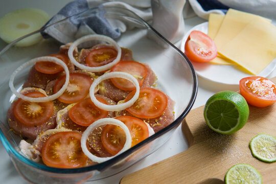 Preparing french meat with tomatoes, cheese, onion, spices and lime 
