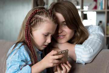 little daughter shows mom something on the phone
