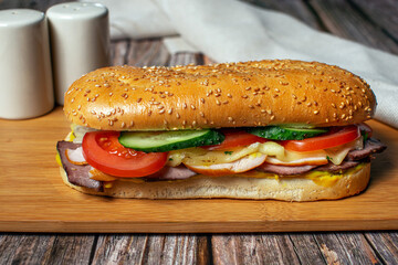Sandwich with sesame bun, cheese, ham and fresh vegetables