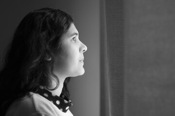 Woman standing in front of the window looking out