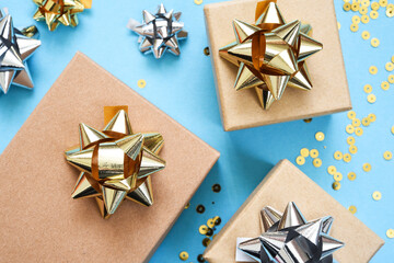 Flat composition for a birthday on a blue background. Fashionable gifts with golden bows.