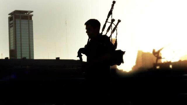 Silhouette of a man playing bagpipes