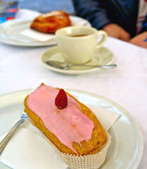 close up detail of delcious pastry bigne with wild strawberry cream and glace with fresh fruit on top and italian espresso coffee    