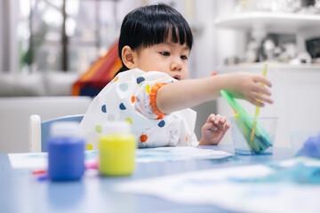 Asian toddler girl is painting water color. toddler activity at home. - 353655415