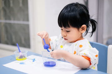 Asian toddler girl is painting water color. toddler activity at home. - 353655459