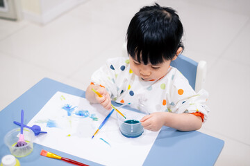 Asian toddler girl is painting water color. toddler activity at home. - 353655479