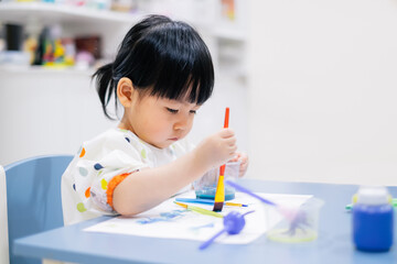 Asian toddler girl is painting water color. toddler activity at home. - 353655497
