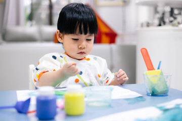 Asian toddler girl is painting water color. toddler activity at home. - 353655617