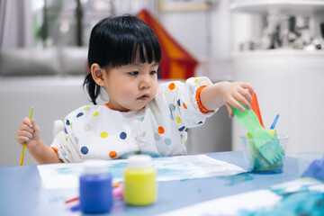 Asian toddler girl is painting water color. toddler activity at home. - 353655634