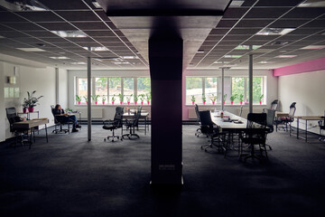 One woman herself in a dark office.