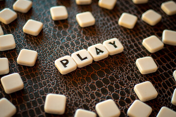 Piezas con letras de un juego de mesa formando la palabra "play"