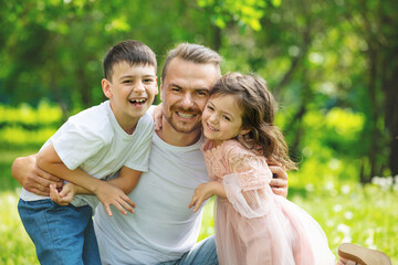 Fototapeta premium Happy beautiful family together father, son and daughter portrait on a walk on a Sunny summer day