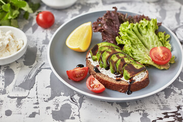 Bruschetta with avocado, cream cheese and balsamic sauce. Vegetarian food
