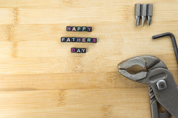 Happy Fathers Day blocks with tools wrench on a rustic wood background