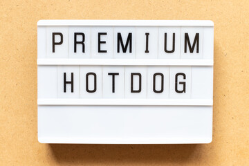 Lightbox with word premium hotdog on wood background