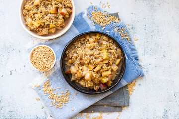 Whole oats granola porridge with fruits - apples and peaches. Vegan breakfast food.