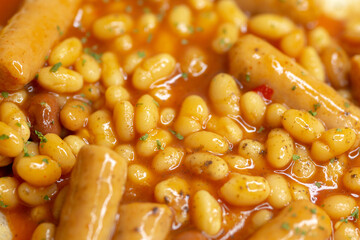 Closeup food photography - beans and sausages with out of focus elements