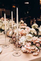Wedding flowers on the banquet table. Table decoration. Table setting and decorations.