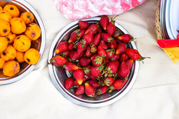 Ripe tropical loquat fruit on plate with strawberry