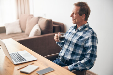 Relaxed mature man looking aside at window