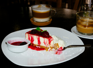 Slice of cheesecake on a plate and cappuccino