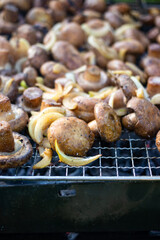 Make, fry mushrooms with onion rings on grill. Vegan food.