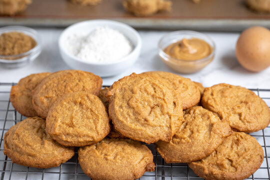 Cookies cooling on a rack, with baking ingredients in the background