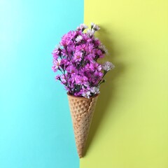 Cutter flower and ice cream cones on pastel colored background. Pink flower in a ice cream cones.