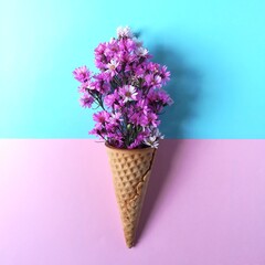 Cutter flower and ice cream cones on pastel colored background. Pink flower in a ice cream cones.