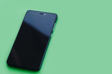 Smartphone lying on green background
