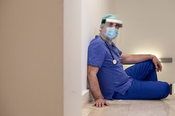 medico con cuffietta e mascherina  in camice blu isolato su sfondo