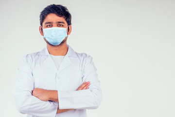 handsome turkey man surgeon doctor wearing white blazer coat arms crossed on the chest and looking at camera in studio background