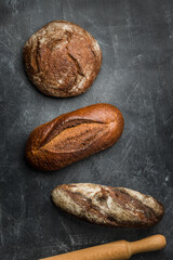 Rustic bread on dark background. Flat lay.