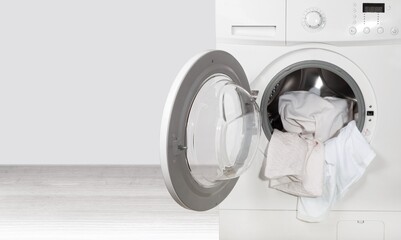 Washing machine with different laundry on background